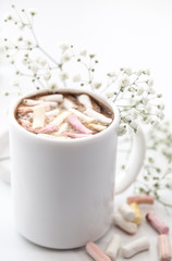 white coffee Cup with marshmallows and flowers