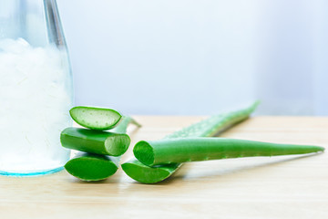 Fresh aloe vera leaves with aloe vera juice in bottle on wooden background