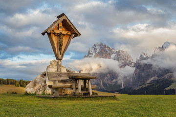 A place to rest beneath Jesus on the cross overlooking the beautiful rock massifs of the Dolomites.
