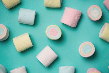 Top view of pastel colored marshmallow on a blue background. Minimalism style.