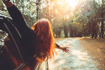 Woman driving a car traveling happily.