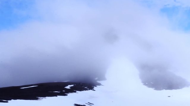 Clouds covering tops of snow-capped mountains (permanent snowdrift ) on island NORTHBROOK, Franz-Josef Land
