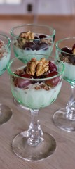 Individual portions of yoghurt with crunch, grapes, coconut flakes and walnut