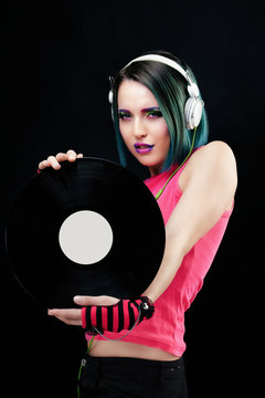 Portrait d'une jeune femme souriante, pr&eacute;sentant un disque vinyle dans ses mains