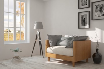 White room with armchair and autumn landscape in window. Scandinavian interior design. 3D illustration