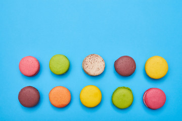 Fototapeta na wymiar Top view of sweet macarons with copy space over blue flatlay