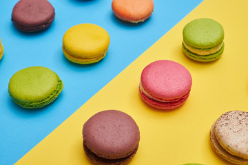 Several french cookies macaroons arranged on a blue flatlay