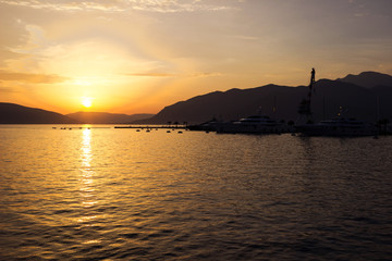 Sunset on the sea, view to sea in the evening. The ships and the mountains