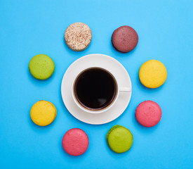 A cup of aroma coffee encircled with a delicious homemade macaroons