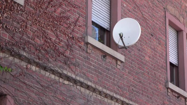 Building, business or home, exterior with satellite dish on exterior.
