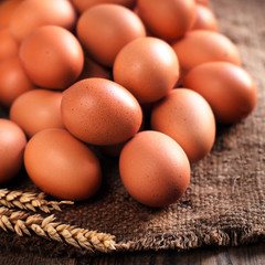 Heap of  eggs on dark wooden  background close up.