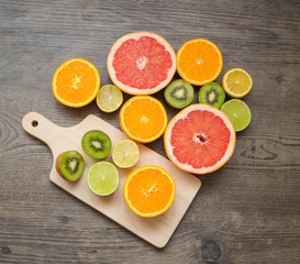 Slices fresh fruits on a table and cutting board.