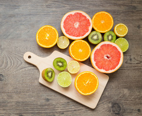 Slices fresh fruits on a table and cutting board.