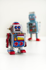 Pair of vintage tin toy robots isolated on white background