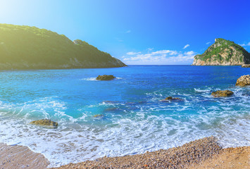 Beautiful summer panoramic seascape. View of the coastline into the sea bays with crystal clear azure water. In the backlight sunbeam light.  Paleokastrica. Corfu. Ionian archipelago. Greece.