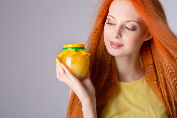 Girl holding a jar of honey.