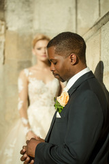 Handsome bearded african American groom touches wedding ring on finger