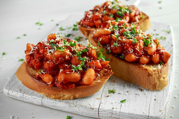 Beans fried in tomato sauce on toasted bread with cross salad sprinkle
