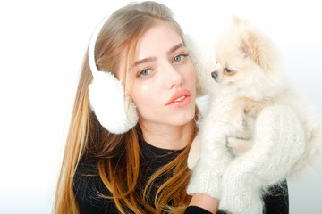 sexy pretty girl with small pomeranian dog in earmuffs