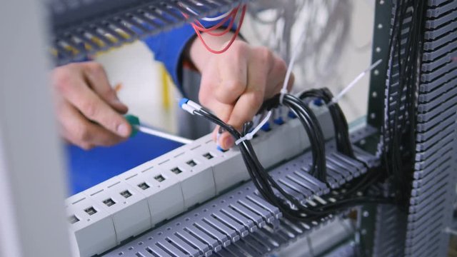 Unrecognizable professional electrician assembling electrical shield. 4K.