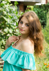 beautiful girl posing in the garden . the height of spring. a green garden a beautiful green background . a tender portrait