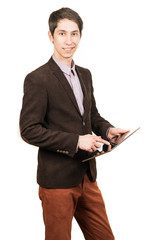 Cheerful young man businessman in suit working on digital tablet and smiling while standing isolated