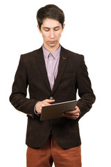 Cheerful young man businessman in suit working on digital tablet and smiling while standing isolated