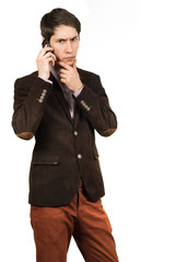 Fototapeta premium Portrait of a young pensive businessman talking on cell phone