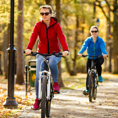Obraz premium Two women riding bicycles in city 