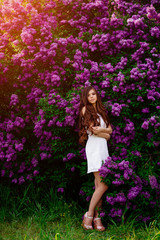 Fototapeta na wymiar girl in white dress in the garden lilac