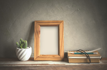 mock up blank photo frame with cactus flower on bookshelf.