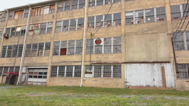 Warehouse or factory in small town where the building has been abandoned and jobs moved elsewhere.
