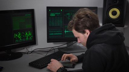 Computer room in the basement. A man checks the information on your smartphone. Information on your computer is displayed at this time. The hacker tries to break into important information.