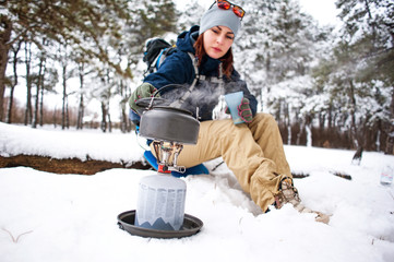 Tourist with backpack, map and navigation in the winter forest