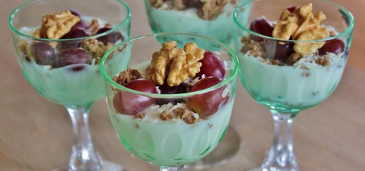 Individual portions of yoghurt with crunch, grapes, coconut flakes and walnut