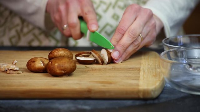 Chopping and slicing fresh mushrooms for a pizza.