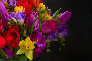Obraz na płótnie Canvas bouquet of bright spring flowers on dark background close up