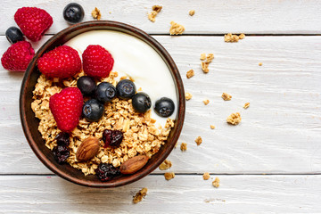 Bowl of homemade granola with greek yogurt and fresh berries