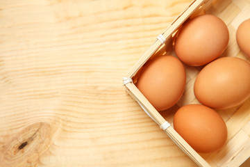 Eggs in a basket on a wooden table background.