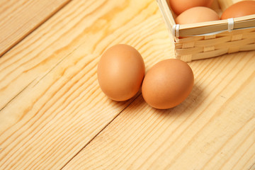 Eggs in a basket on a wooden table background.