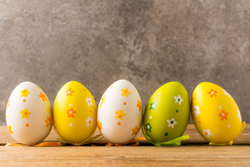 Easter eggs on wooden table and stone background