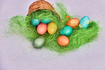 Easter basket filled with colorful eggs on a white background