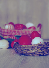 Easter eggs in nest on wooden background. Easter eggs in basket.