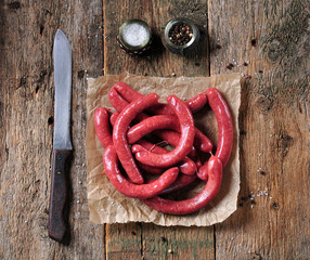 Raw sausages from beef meat on an old wooden background.