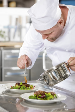 Focused professional chef prepare meat dish at restaurant