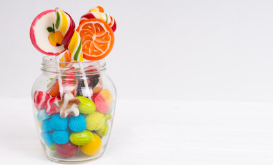 Tasty chewing sweets, bright lollipops and jelly candies in the glass can