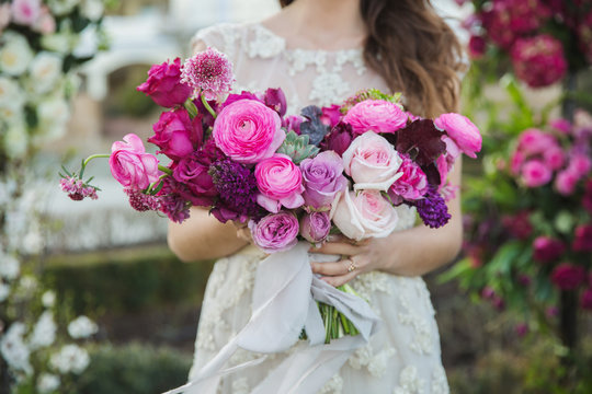 Bride with beautiful wedding bouquet. Pink rose and other flowers.