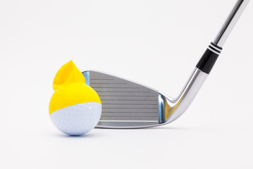 White golf ball with funny cap and golf club on the white background.