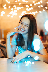 Woman holding glowing christmas garland in hands