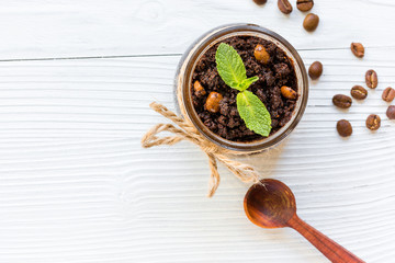 Body scrub of ground coffee on white table background top view
